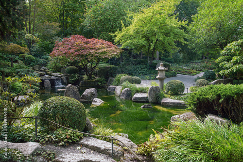 Small and beautiful japanese garden in Wurzburg with artificial creek, waterfalls, decorative lanterns and japanese maples