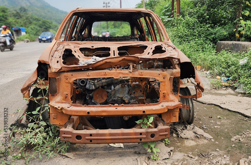 old rusty engine  Old rusted torched car  abandoned car on highway mumbai.