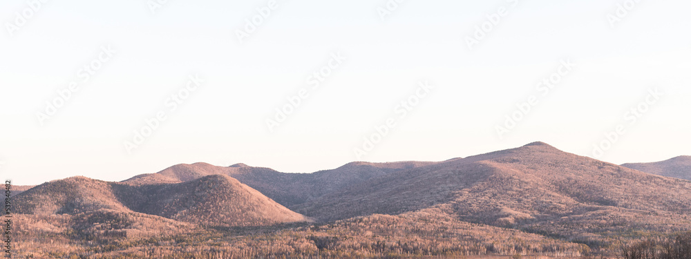 Aerial view of mountain hills, a mountain background with a copy space - the concept of tourism and travel. Beautiful panoramic landscape of mountain peaks.