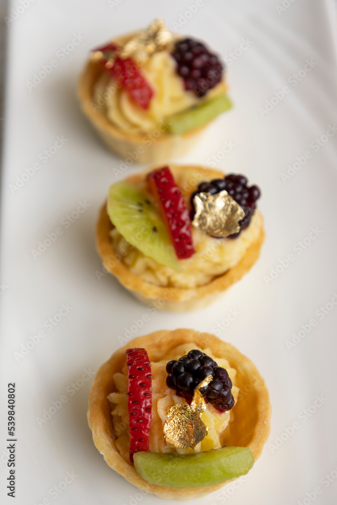 studio, gourmet food served on a plate decorated with tropical fruits and cream, cake as an appetizer studio, gourmet food served on a plate decorated with tropical fruits and cream, cake as an appetizer