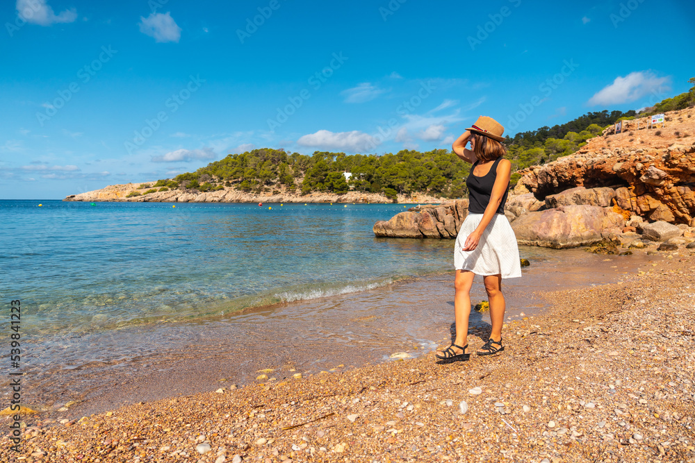A young woman with a hat in Ibiza at Salada y Saladeta beach. Balearic