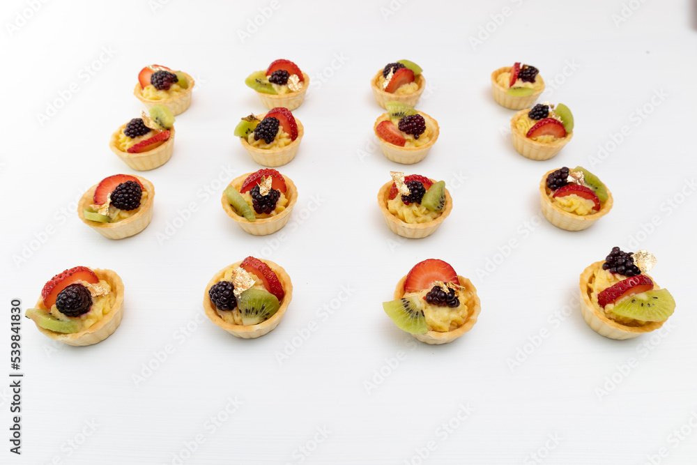 rows of delicious cupcakes with cream and fruits as decoration, details in studio, gourmet food with white background, pastries rows of delicious cupcakes with cream and fruits as decoration, details in studio, gourmet food with white background, pastries