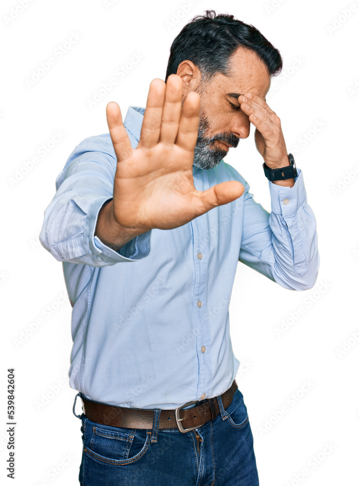 Middle aged man with beard wearing business shirt covering eyes with hands and doing stop gesture with sad and fear expression. embarrassed and negative concept. - obrazy, fototapety, plakaty 