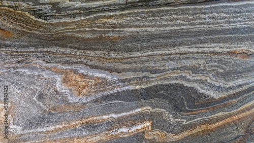 A metamorphic rock called gneiss makes pleasing patterns along its surface. photo