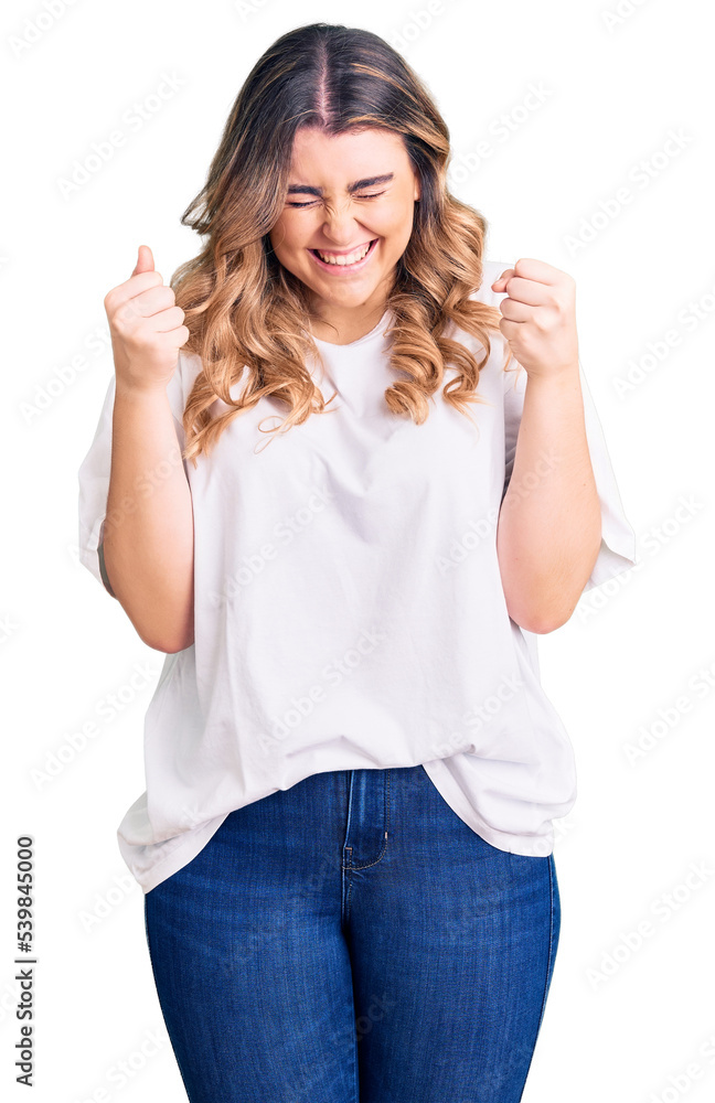 Young caucasian woman wearing casual clothes excited for success with arms raised and eyes closed celebrating victory smiling. winner concept. Young caucasian woman wearing casual clothes excited for success with arms raised and eyes closed celebrating victory smiling. winner concept.