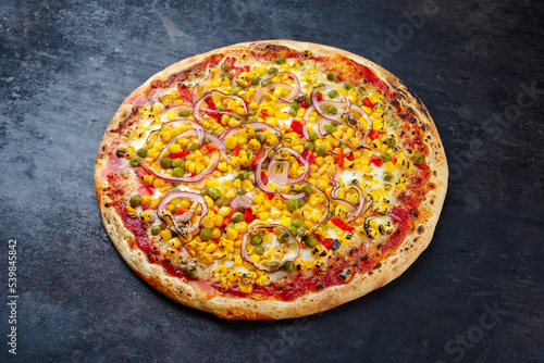 Traditionelle italienische Pizza Mexico mit Mais, Erbsen und Paprika serviert als Draufsicht auf einem alten rustikalen Board mit Textfreiraum 
