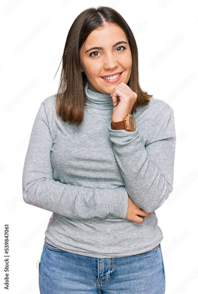 Young beautiful woman wearing casual turtleneck sweater looking confident at the camera smiling with crossed arms and hand raised on chin. thinking positive. Young beautiful woman wearing casual turtleneck sweater looking confident at the camera smiling with crossed arms and hand raised on chin. thinking positive.
