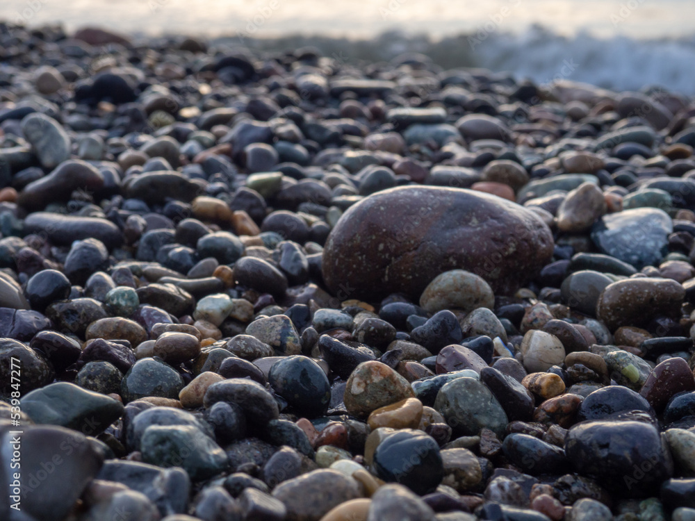 Pebbles on the seashore close-up. Rocky beach. Stones close-up with bokeh. Gray natural background. The concept of rest on the seashore. The Velvet season. Waves and wet pebbles Pebbles on the seashore close-up. Rocky beach. Stones close-up with bokeh. Gray natural background. The concept of rest on the seashore. The Velvet season. Waves and wet pebbles