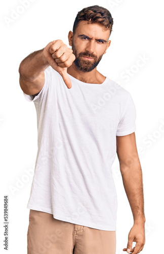 Young hispanic man wearing casual white tshirt looking unhappy and angry showing rejection and negative with thumbs down gesture. bad expression.