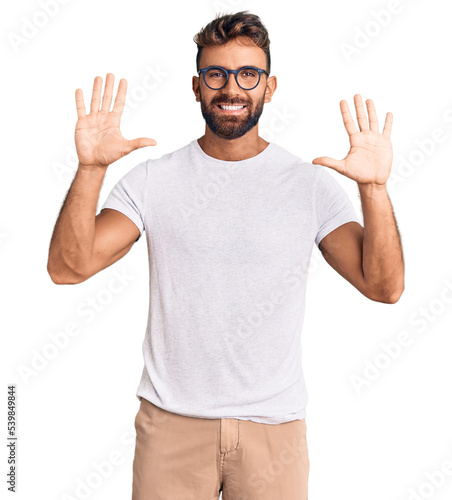 Young hispanic man wearing casual clothes and glasses showing and pointing up with fingers number ten while smiling confident and happy.