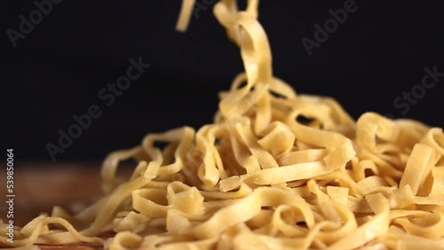Preparing homemade egg pasta. Female hands raise and throw pasta on the table. High quality FullHD footage