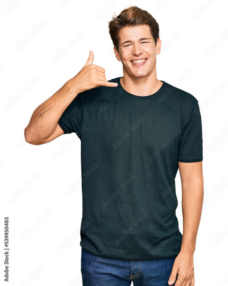 Handsome caucasian man wearing casual clothes smiling doing phone gesture with hand and fingers like talking on the telephone. communicating concepts. Handsome caucasian man wearing casual clothes smiling doing phone gesture with hand and fingers like talking on the telephone. communicating concepts.