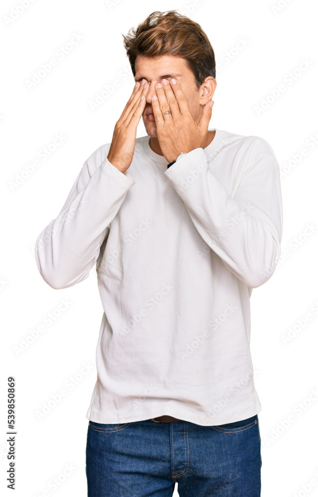 Handsome caucasian man wearing casual white sweater rubbing eyes for fatigue and headache, sleepy and tired expression. vision problem Handsome caucasian man wearing casual white sweater rubbing eyes for fatigue and headache, sleepy and tired expression. vision problem