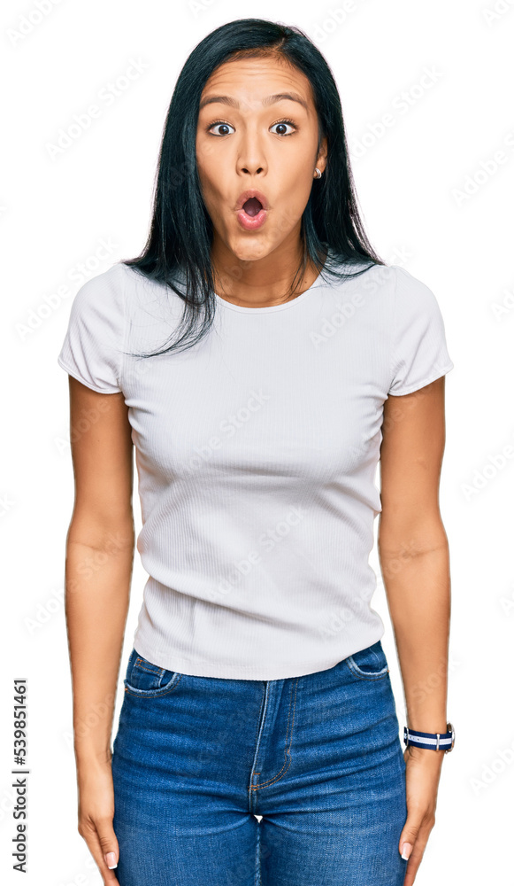 Obraz premium Beautiful hispanic woman wearing casual white tshirt afraid and shocked with surprise and amazed expression, fear and excited face.