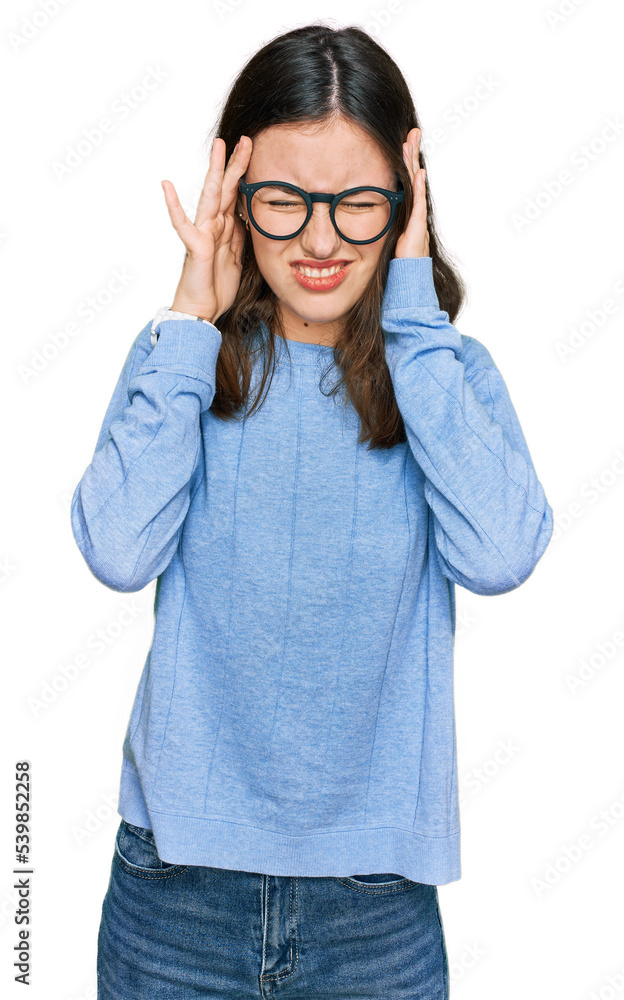 Young beautiful woman wearing casual clothes and glasses with hand on head, headache because stress. suffering migraine. Young beautiful woman wearing casual clothes and glasses with hand on head, headache because stress. suffering migraine.