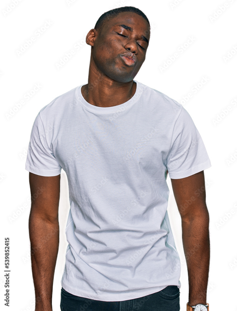 Young african american man wearing casual white t shirt looking at the camera blowing a kiss on air being lovely and sexy. love expression.
