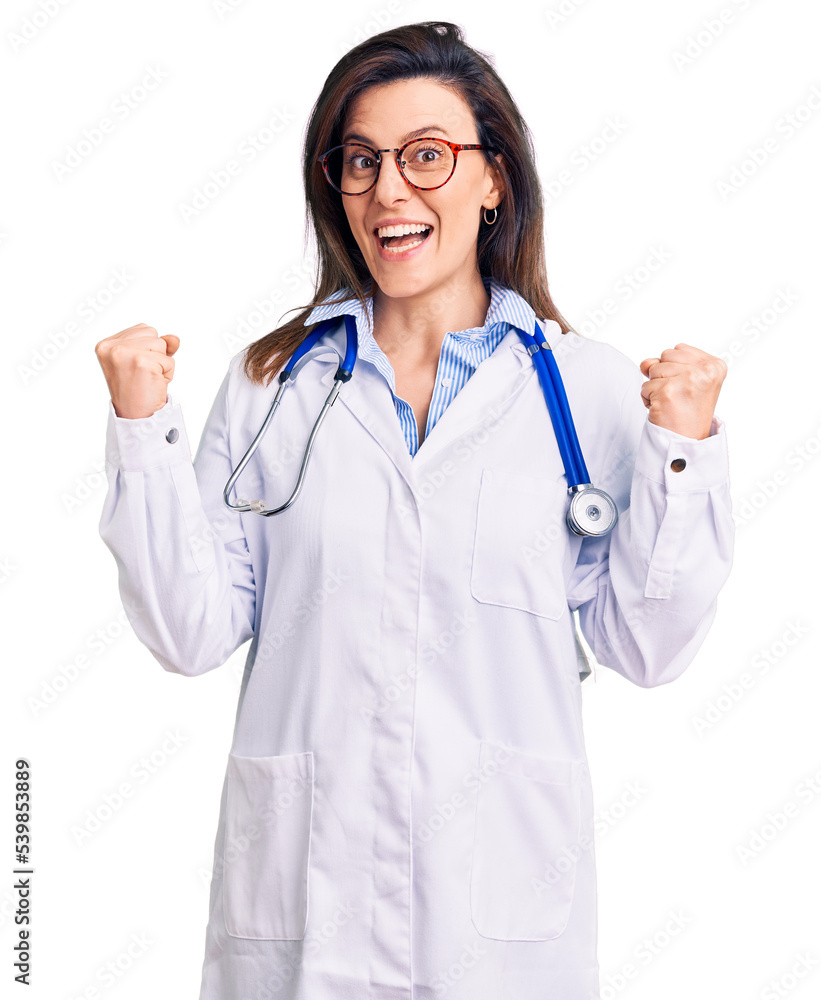 Young beautiful woman wearing doctor stethoscope and glasses celebrating surprised and amazed for success with arms raised and open eyes. winner concept. Young beautiful woman wearing doctor stethoscope and glasses celebrating surprised and amazed for success with arms raised and open eyes. winner concept.