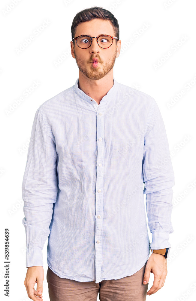 Handsome young man with bear wearing elegant business shirt and glasses making fish face with lips, crazy and comical gesture. funny expression. Handsome young man with bear wearing elegant business shirt and glasses making fish face with lips, crazy and comical gesture. funny expression.