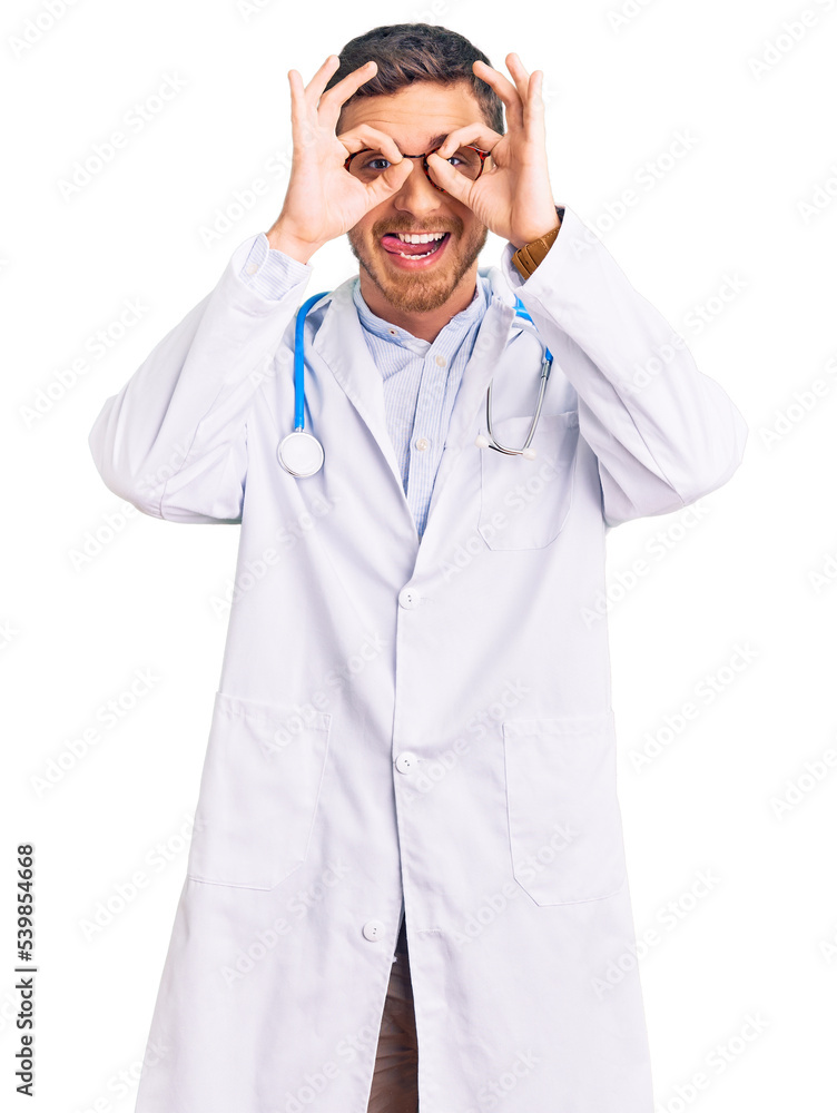 Handsome young man with bear wearing doctor uniform doing ok gesture like binoculars sticking tongue out, eyes looking through fingers. crazy expression. Handsome young man with bear wearing doctor uniform doing ok gesture like binoculars sticking tongue out, eyes looking through fingers. crazy expression.
