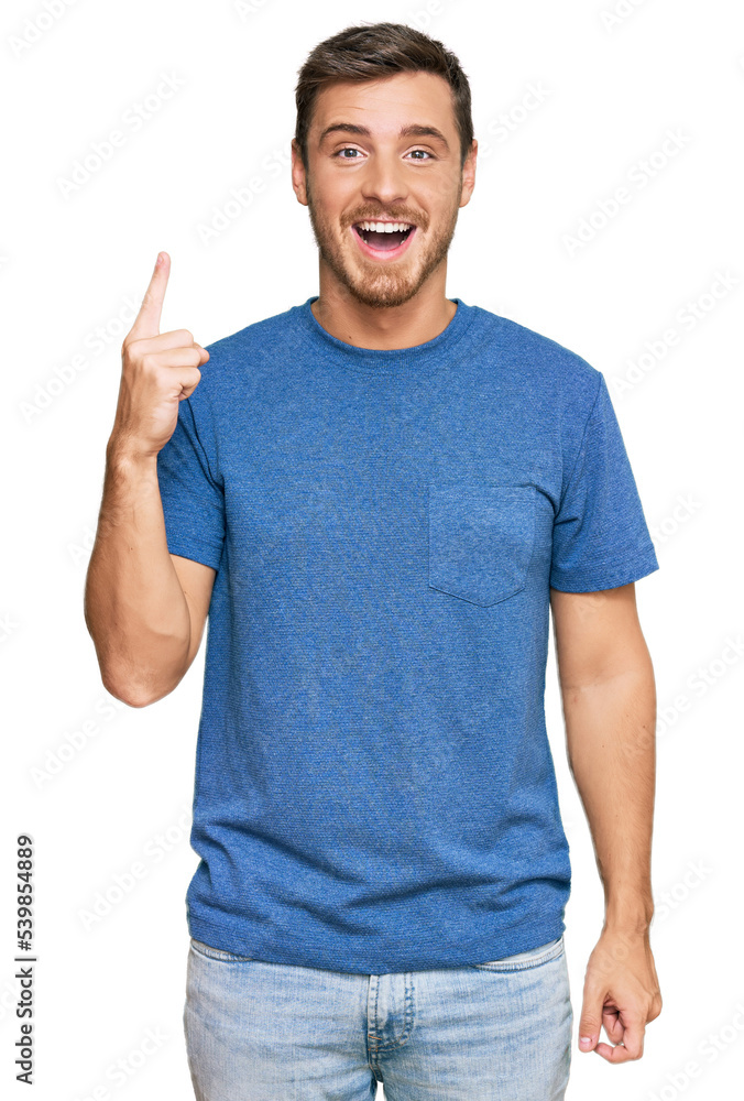 Handsome caucasian man wearing casual clothes pointing finger up with successful idea. exited and happy. number one. Handsome caucasian man wearing casual clothes pointing finger up with successful idea. exited and happy. number one.