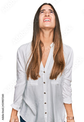 Young beautiful woman wearing casual clothes angry and mad screaming frustrated and furious, shouting with anger. rage and aggressive concept. © Krakenimages.com