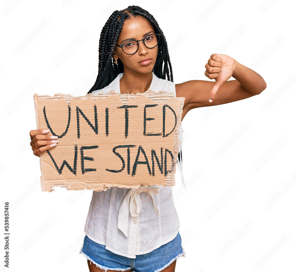 Beautiful hispanic woman holding united we stand banner with angry face, negative sign showing dislike with thumbs down, rejection concept Beautiful hispanic woman holding united we stand banner with angry face, negative sign showing dislike with thumbs down, rejection concept