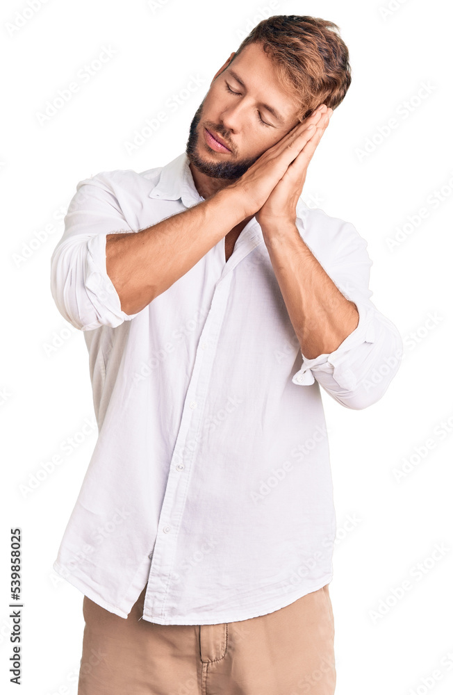 Young caucasian man wearing casual clothes sleeping tired dreaming and posing with hands together while smiling with closed eyes. Young caucasian man wearing casual clothes sleeping tired dreaming and posing with hands together while smiling with closed eyes.