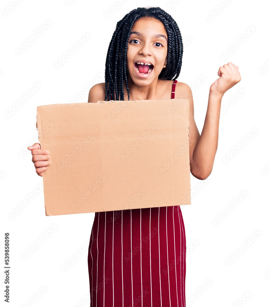 Cute african american girl holding empty banner screaming proud, celebrating victory and success very excited with raised arms Cute african american girl holding empty banner screaming proud, celebrating victory and success very excited with raised arms