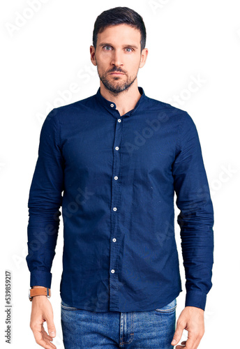 Young handsome man wearing casual shirt relaxed with serious expression on face. simple and natural looking at the camera.