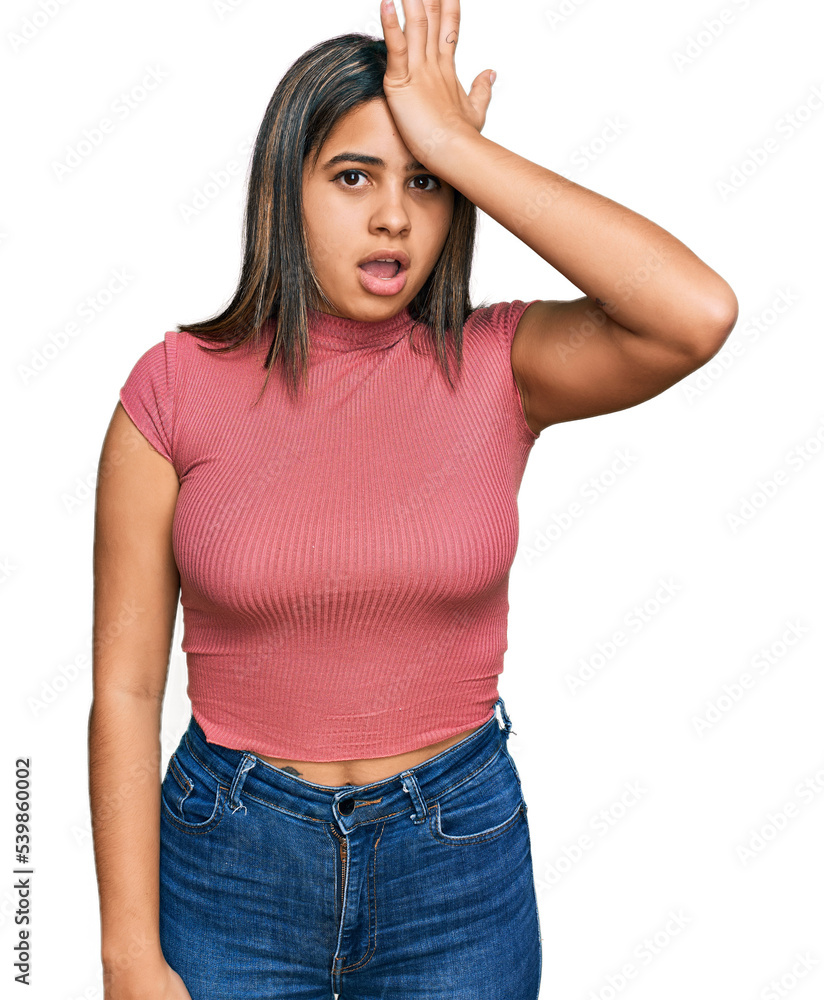 Young hispanic girl wearing casual t shirt surprised with hand on head for mistake, remember error. forgot, bad memory concept. Young hispanic girl wearing casual t shirt surprised with hand on head for mistake, remember error. forgot, bad memory concept.