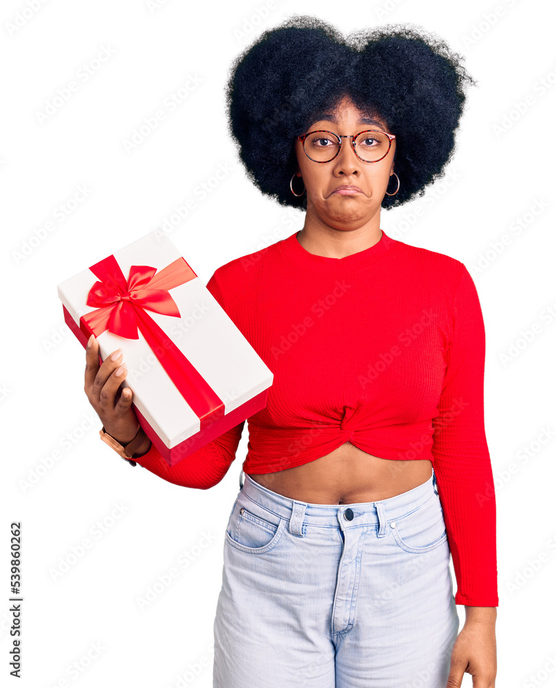 Young african american girl holding gift depressed and worry for distress, crying angry and afraid. sad expression. Young african american girl holding gift depressed and worry for distress, crying angry and afraid. sad expression.