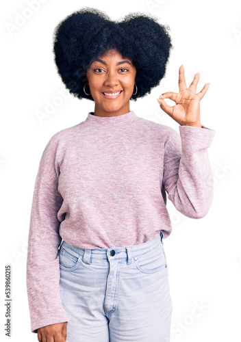 Young african american girl wearing casual clothes smiling positive doing ok sign with hand and fingers. successful expression.