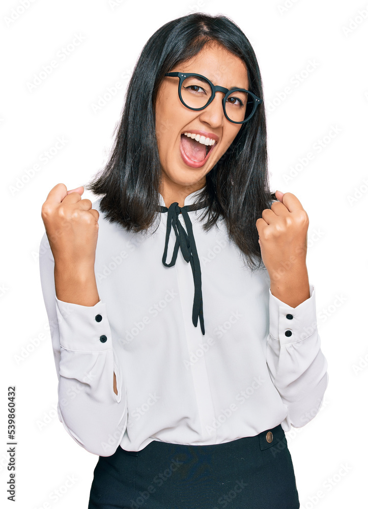Beautiful asian young woman wearing business shirt and glasses screaming proud, celebrating victory and success very excited with raised arms Beautiful asian young woman wearing business shirt and glasses screaming proud, celebrating victory and success very excited with raised arms
