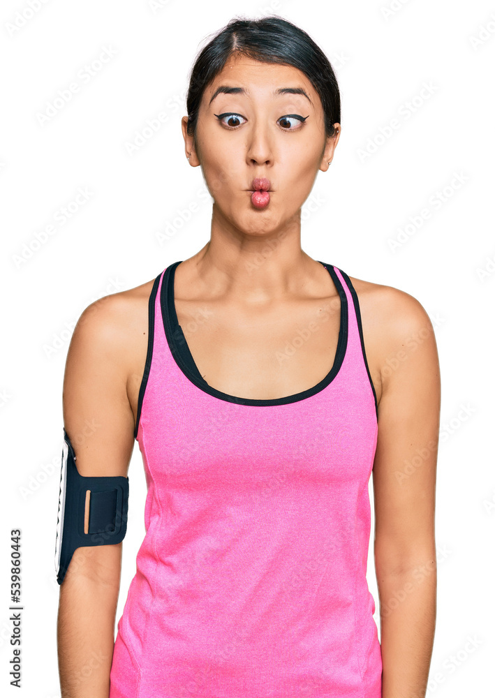Beautiful asian young sport woman wearing sportswear and arm band making fish face with lips, crazy and comical gesture. funny expression. Beautiful asian young sport woman wearing sportswear and arm band making fish face with lips, crazy and comical gesture. funny expression.