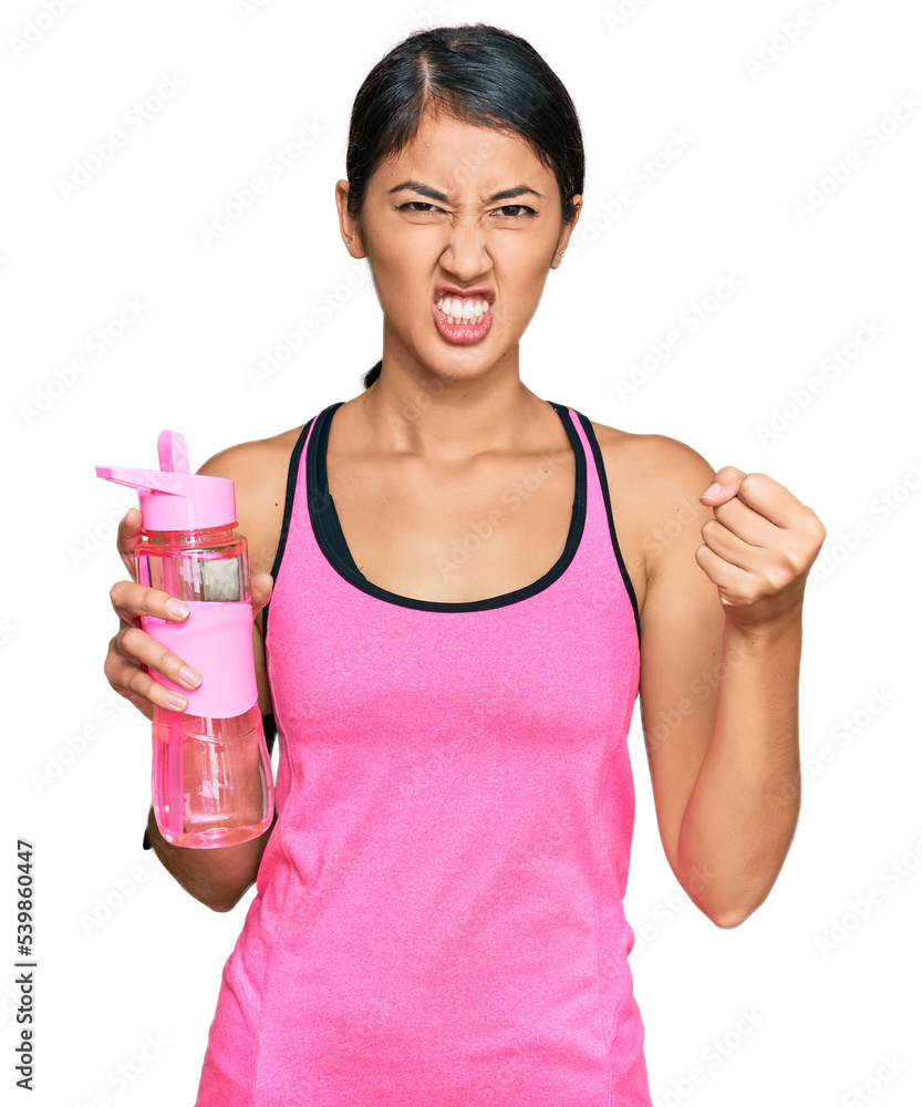 Beautiful asian young sport woman wearing sportswear drinking bottle of water annoyed and frustrated shouting with anger, yelling crazy with anger and hand raised Beautiful asian young sport woman wearing sportswear drinking bottle of water annoyed and frustrated shouting with anger, yelling crazy with anger and hand raised