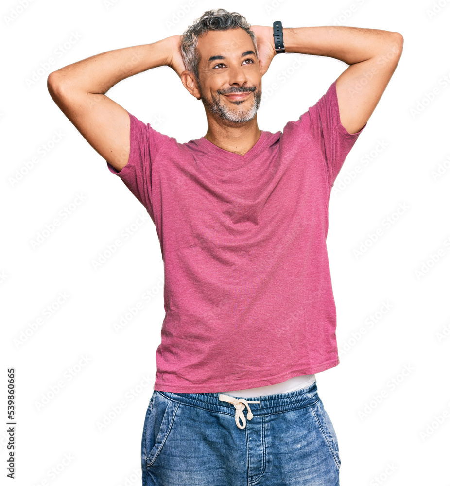 Middle age grey-haired man wearing casual clothes relaxing and stretching, arms and hands behind head and neck smiling happy Middle age grey-haired man wearing casual clothes relaxing and stretching, arms and hands behind head and neck smiling happy