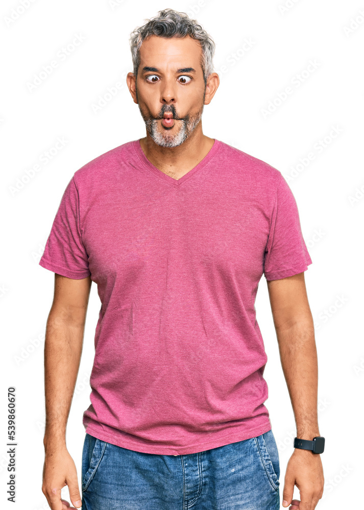 Middle age grey-haired man wearing casual clothes making fish face with lips, crazy and comical gesture. funny expression. Middle age grey-haired man wearing casual clothes making fish face with lips, crazy and comical gesture. funny expression.