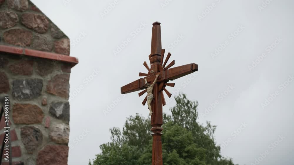 Figurine of crucified Jesus Christ on wooden cross yard of church. Figurine of crucified Jesus Christ on wooden cross yard of church.