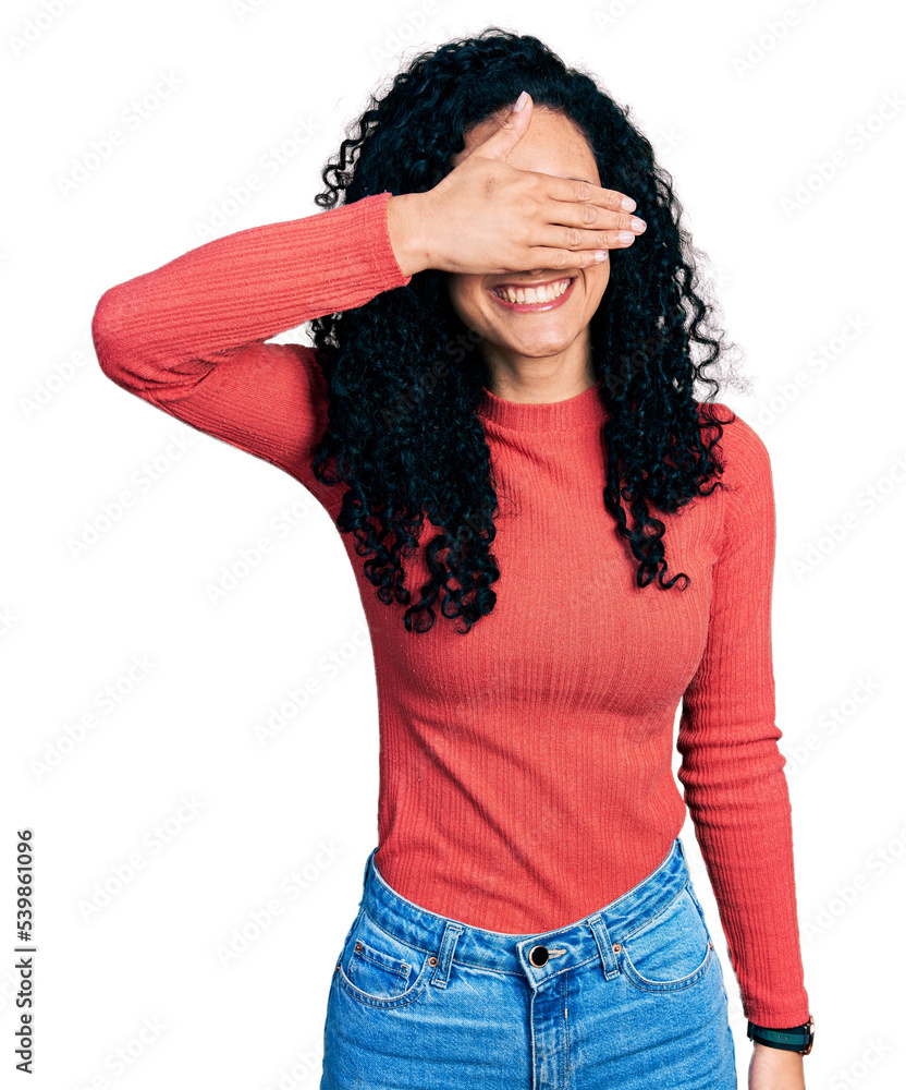 Young hispanic woman with curly hair wearing glasses smiling and laughing with hand on face covering eyes for surprise. blind concept. Young hispanic woman with curly hair wearing glasses smiling and laughing with hand on face covering eyes for surprise. blind concept.
