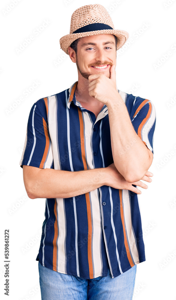 Young handsome caucasian man wearing summer hat with hand on chin thinking about question, pensive expression. smiling with thoughtful face. doubt concept. Young handsome caucasian man wearing summer hat with hand on chin thinking about question, pensive expression. smiling with thoughtful face. doubt concept.