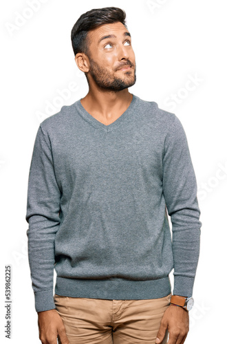 Handsome hispanic man wearing casual clothes smiling looking to the side and staring away thinking.