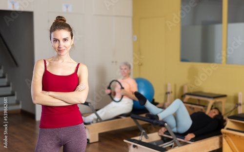 Portrait of a young European woman standing in a fitness studio at a Pilates workout
