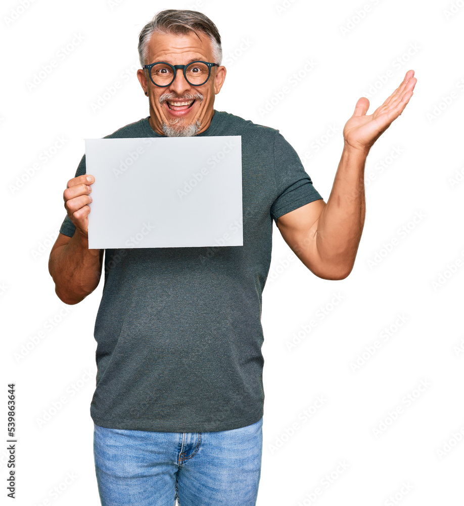 Middle age grey-haired man holding blank empty banner celebrating victory with happy smile and winner expression with raised hands Middle age grey-haired man holding blank empty banner celebrating victory with happy smile and winner expression with raised hands