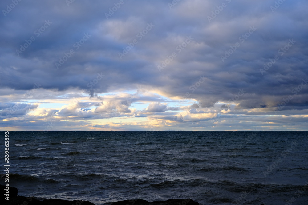 Wind and clouds sweep over the lake on an autumn evening