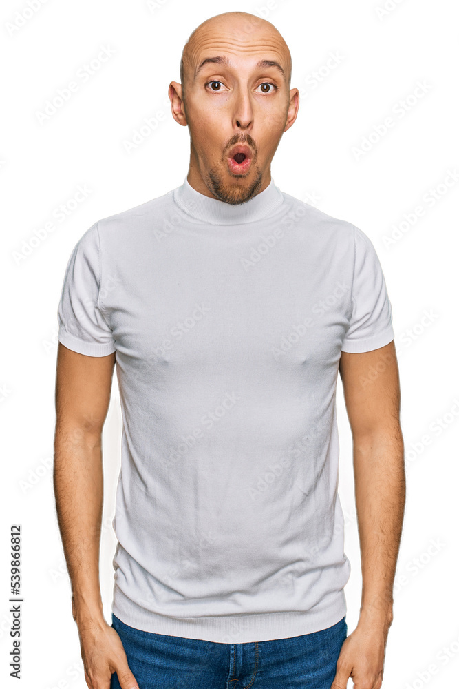 Bald man with beard wearing casual white t shirt afraid and shocked with surprise expression, fear and excited face. Bald man with beard wearing casual white t shirt afraid and shocked with surprise expression, fear and excited face.