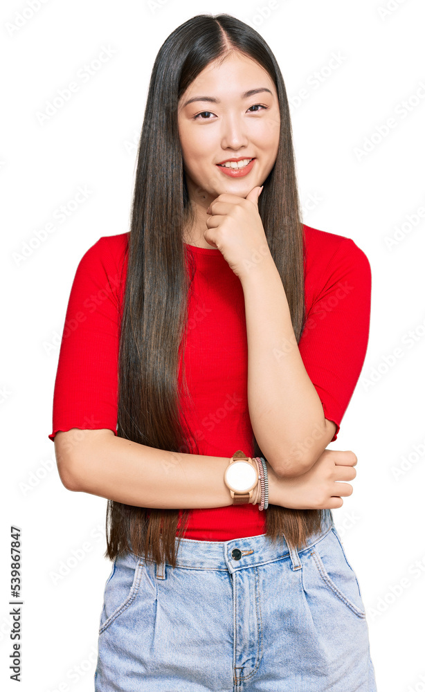 Young chinese woman wearing casual clothes looking confident at the camera smiling with crossed arms and hand raised on chin. thinking positive. Young chinese woman wearing casual clothes looking confident at the camera smiling with crossed arms and hand raised on chin. thinking positive.