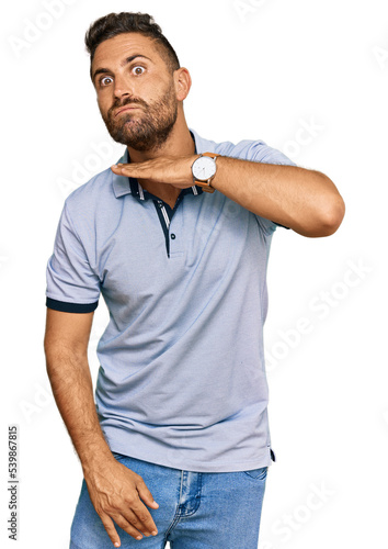 Handsome man with beard wearing casual clothes cutting throat with hand as knife, threaten aggression with furious violence © Krakenimages.com