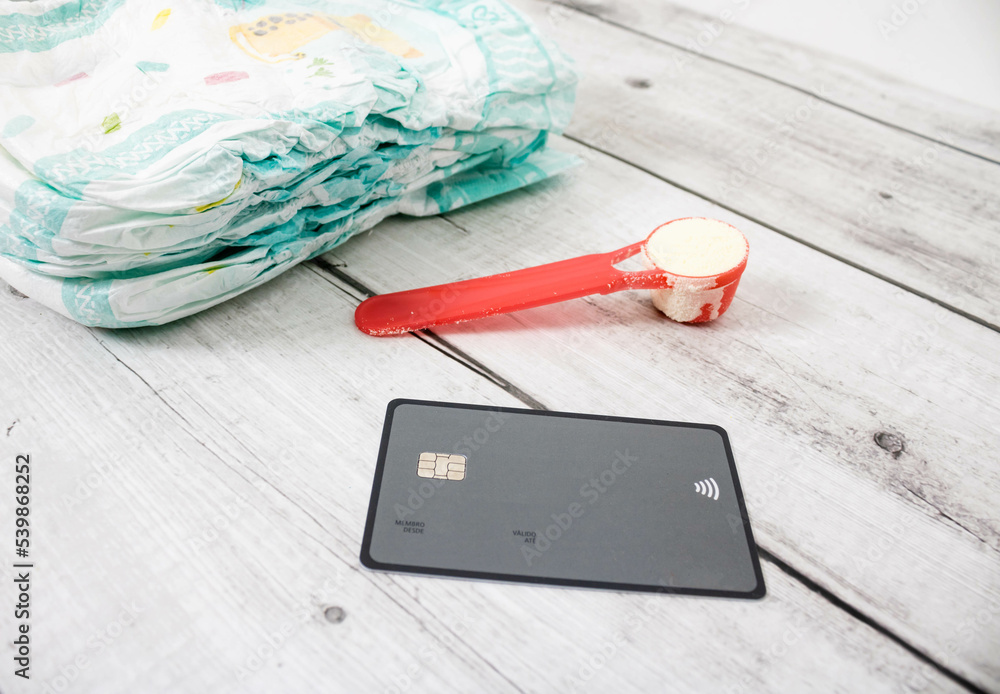 Infant formula in a dispenser with diapers and credit card. It is