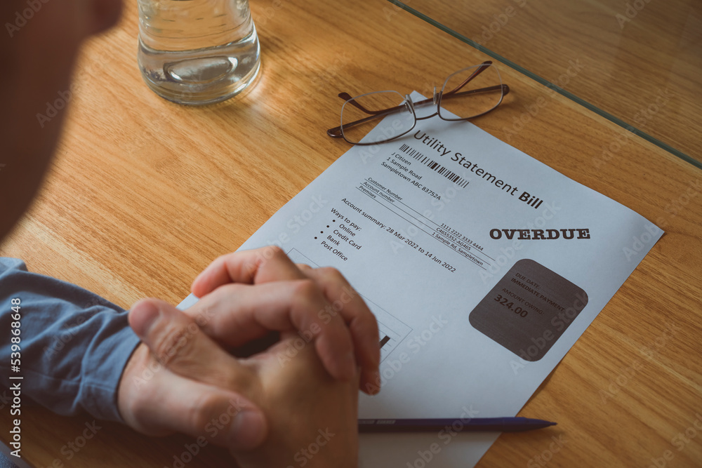 Φωτογραφία A person is looking at their overdue utility statement bill