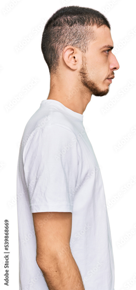 Hispanic young man wearing casual white t shirt looking to side, relax profile pose with natural face with confident smile. Hispanic young man wearing casual white t shirt looking to side, relax profile pose with natural face with confident smile.